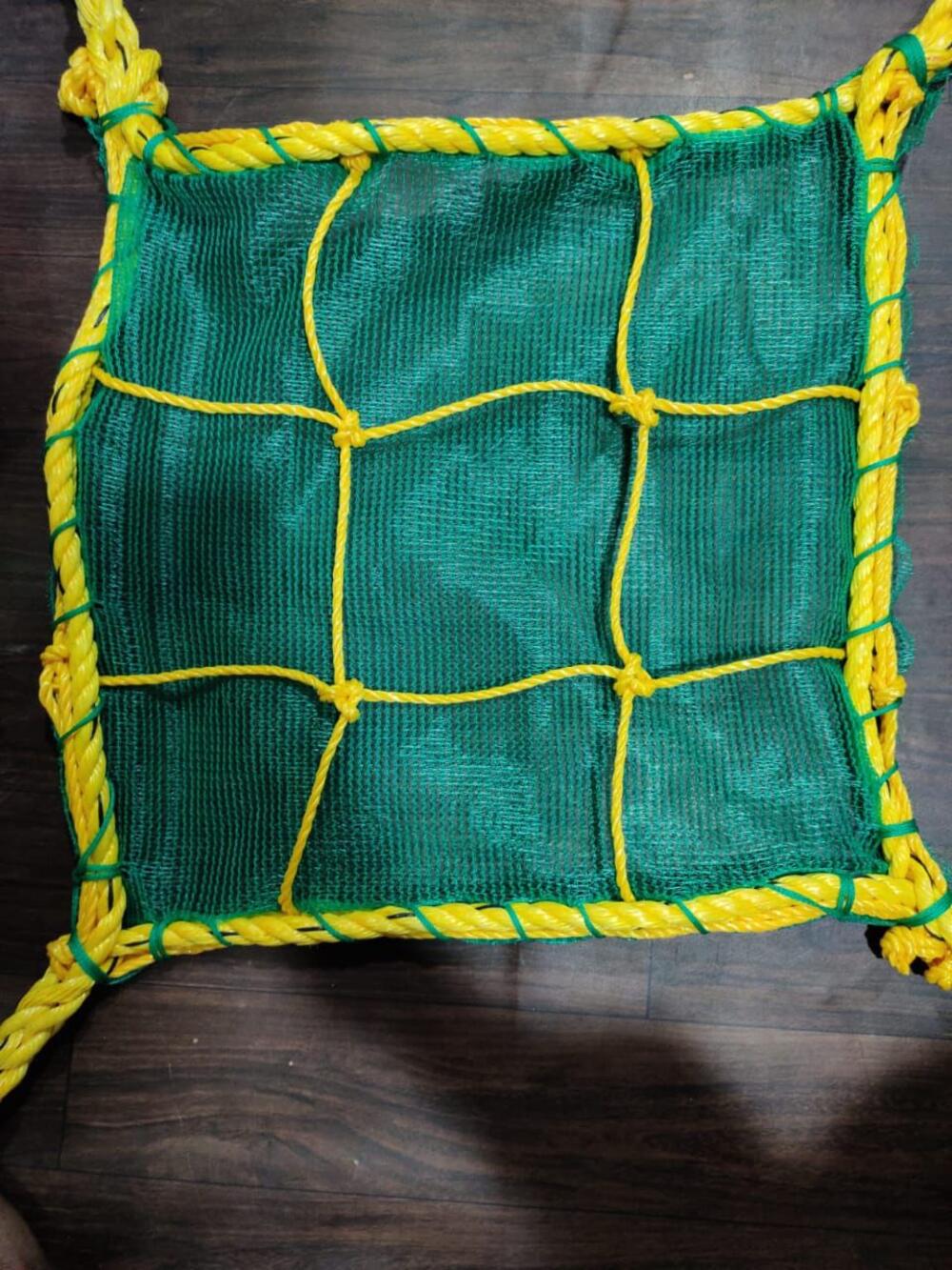 Knotted safety net — green HDPE mesh over a yellow PP rope grid with roped border
